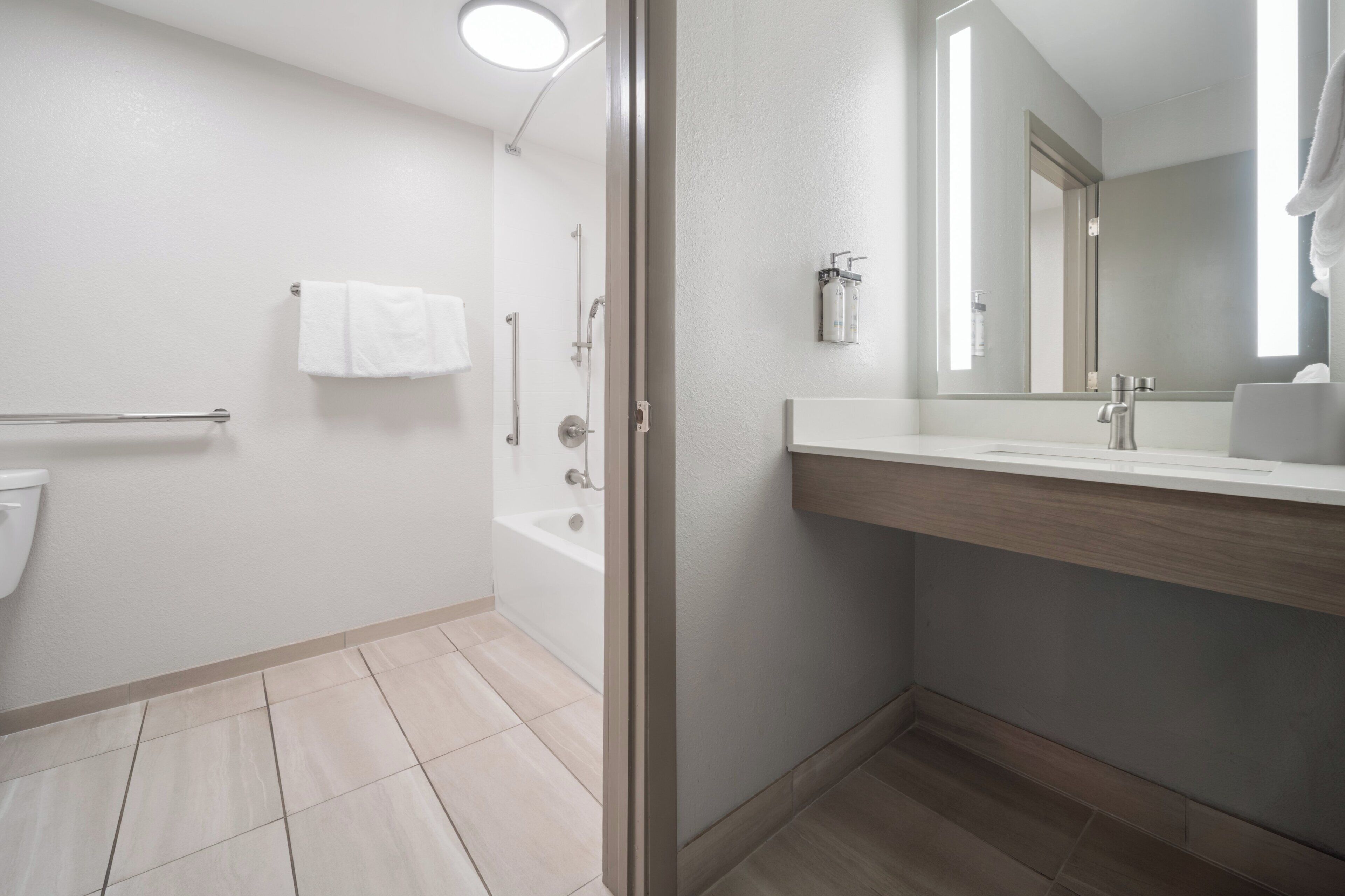 Une salle de bain moderne équipée d’une baignoire, de toilettes, d’un lavabo et d’un miroir.