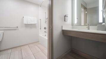 Une salle de bain moderne équipée d’une baignoire, de toilettes, d’un lavabo et d’un miroir.