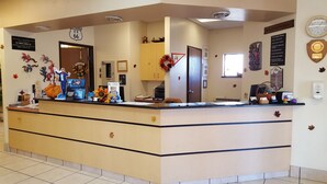 A reception desk with a clock, a 'Welcome' sign, and a 'Best Rewards' sign.