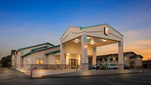 A hotel with a large parking lot, a covered entrance, and a sign indicating it is a Super 8 hotel.