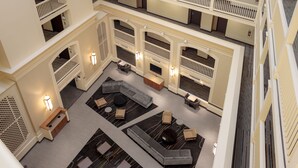 Eine mehrstöckige Hotelhalle mit einer zentralen Sitzecke, mehreren Balkonen und einem modernen Design.