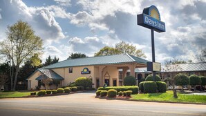 A Days Inn with a prominent sign, a well-maintained lawn, and a clear sky. - Days Inn by Wyndham Thomaston (Thomaston)