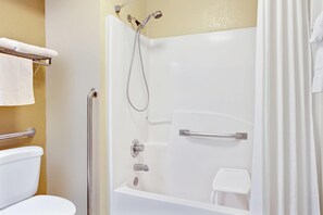 A white bathtub with a showerhead, a grab bar, and a towel rack. - Days Inn & Suites by Wyndham Stockbridge South Atlanta (Stockbridge)