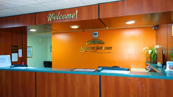 Un mostrador de recepción con un letrero de 'Welcome!' y la marca 'Howard Johnson'.
