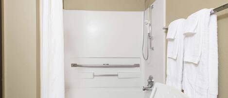 A bathroom with a shower, toilet, and towel rack.