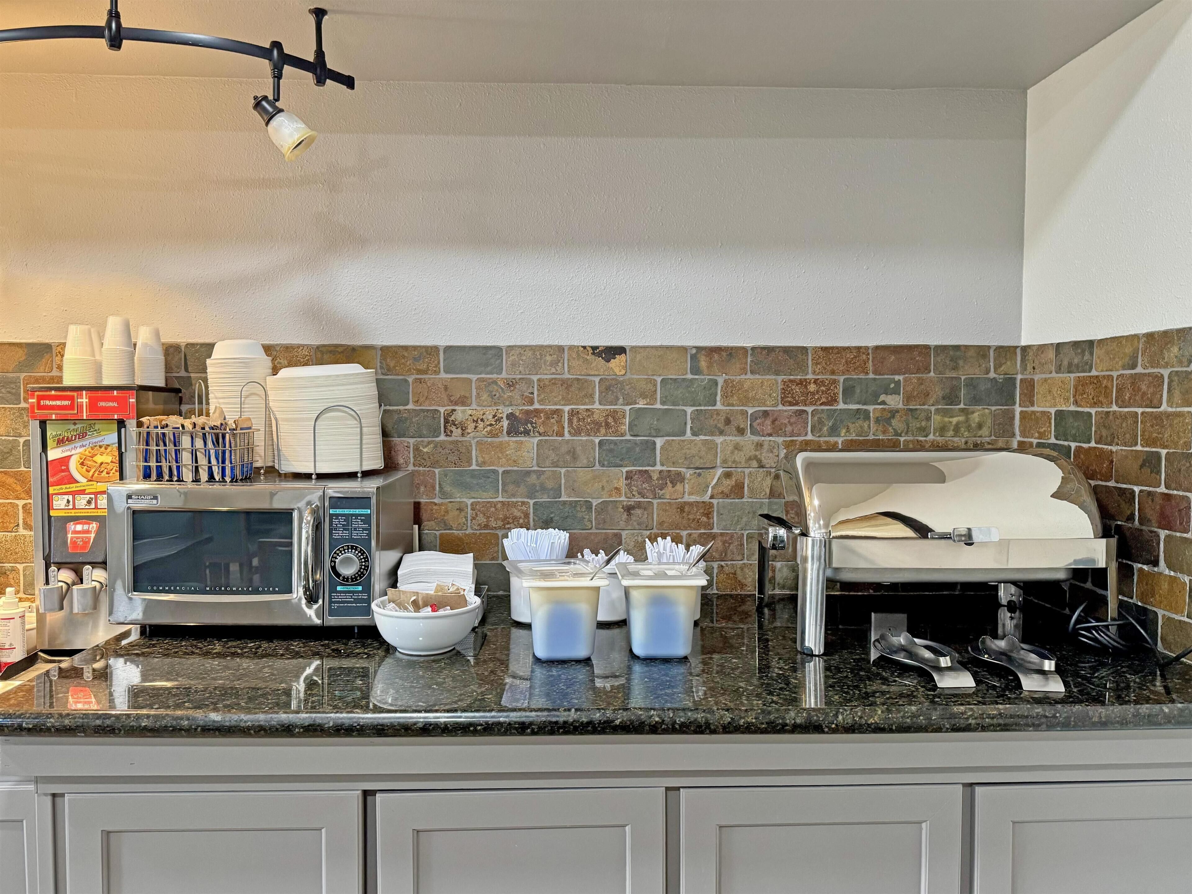 A kitchen with a commercial microwave oven, a coffee machine, and a toaster.