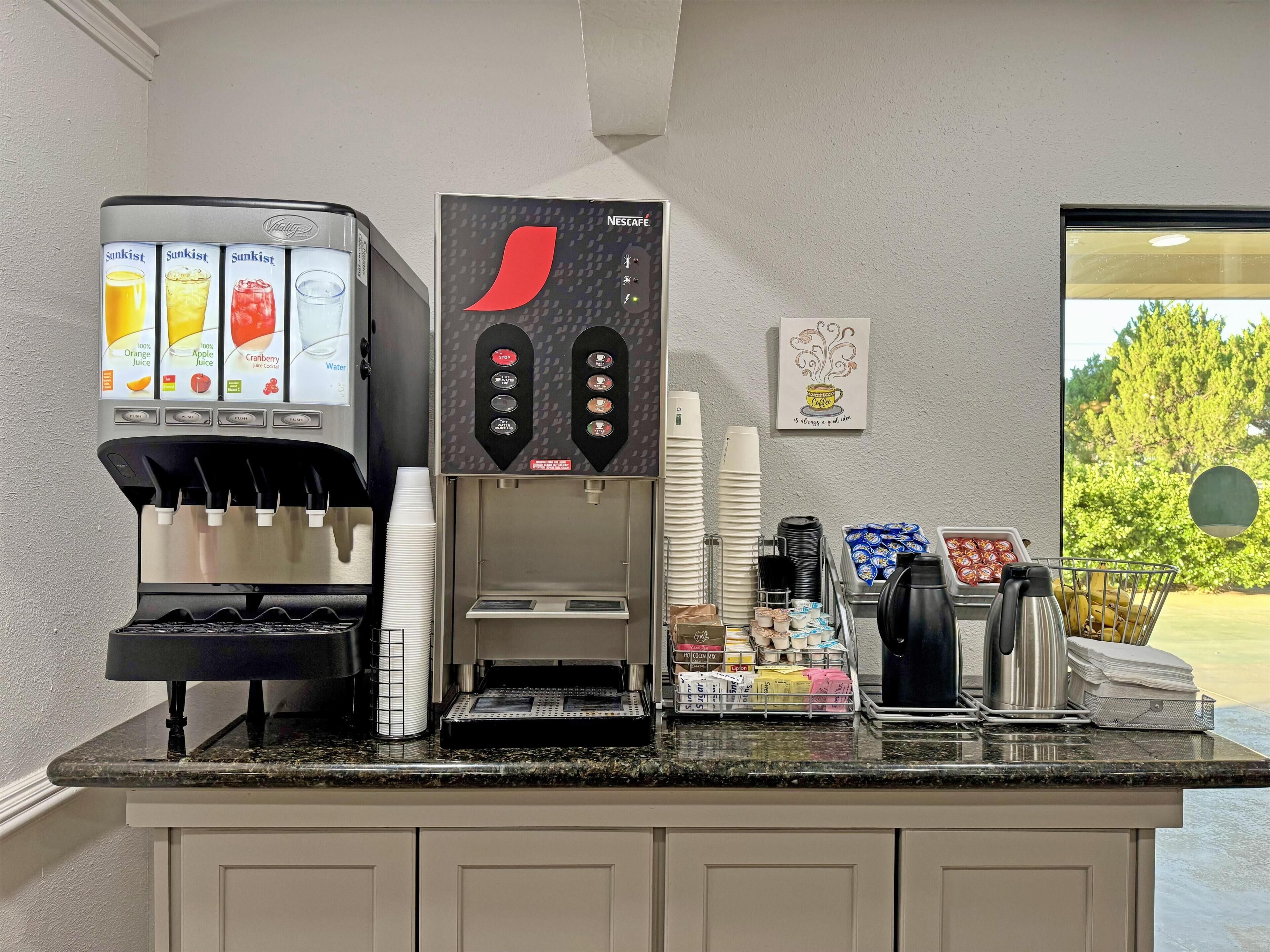 A coffee station with a Nescafe machine and a Sunkist juice dispenser.