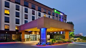 Un hôtel Holiday Inn Express doté d’une entrée couverte, d’un éclairage extérieur et d’un jardin aménagé.