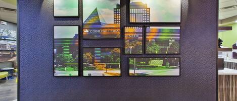 A wall with framed pictures of buildings and a sign that reads 'COBB GALLERY CENTRE'.
