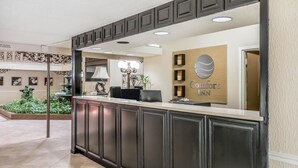 A reception area with a dark wooden reception desk, a chandelier, and a sign that reads "Comfort Inn." - Comfort Inn Savannah Midtown (Savannah)