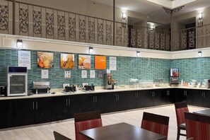 Un espace cuisine moderne, aménagé avec un buffet, comprenant une machine à café, un four à micro-ondes et divers éléments de présentation des aliments.