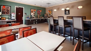 A restaurant with booths and high tables, a coffee machine, and various food displays. - Best Western Plus Roswell / Alpharetta (Roswell)