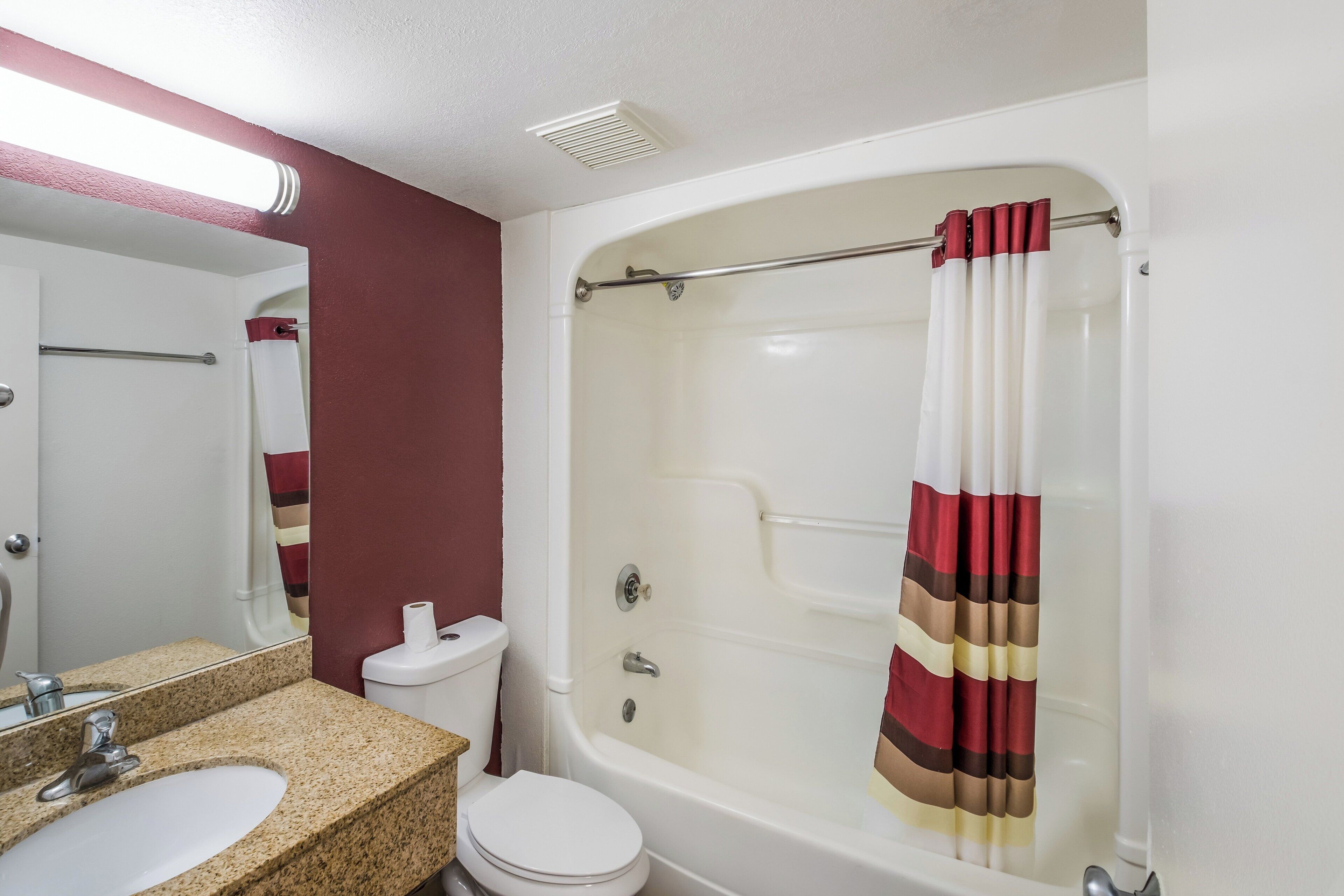 A bathroom with a white sink, toilet, and bathtub.