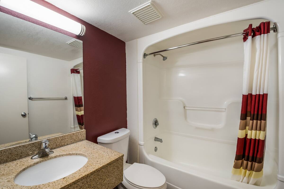 A bathroom with a sink, toilet, and bathtub.