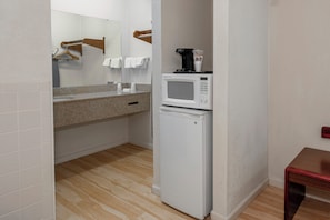 A compact kitchenette with a microwave, a small refrigerator, and a countertop with a coffee maker. - Red Roof Inn & Suites Rome (Rome)