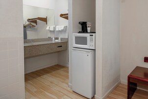 A compact kitchenette with a microwave, a small refrigerator, and a countertop with a coffee maker.