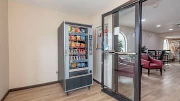 En automataffär fylld med snacks och en ingång till ett rum med en glasdörr.