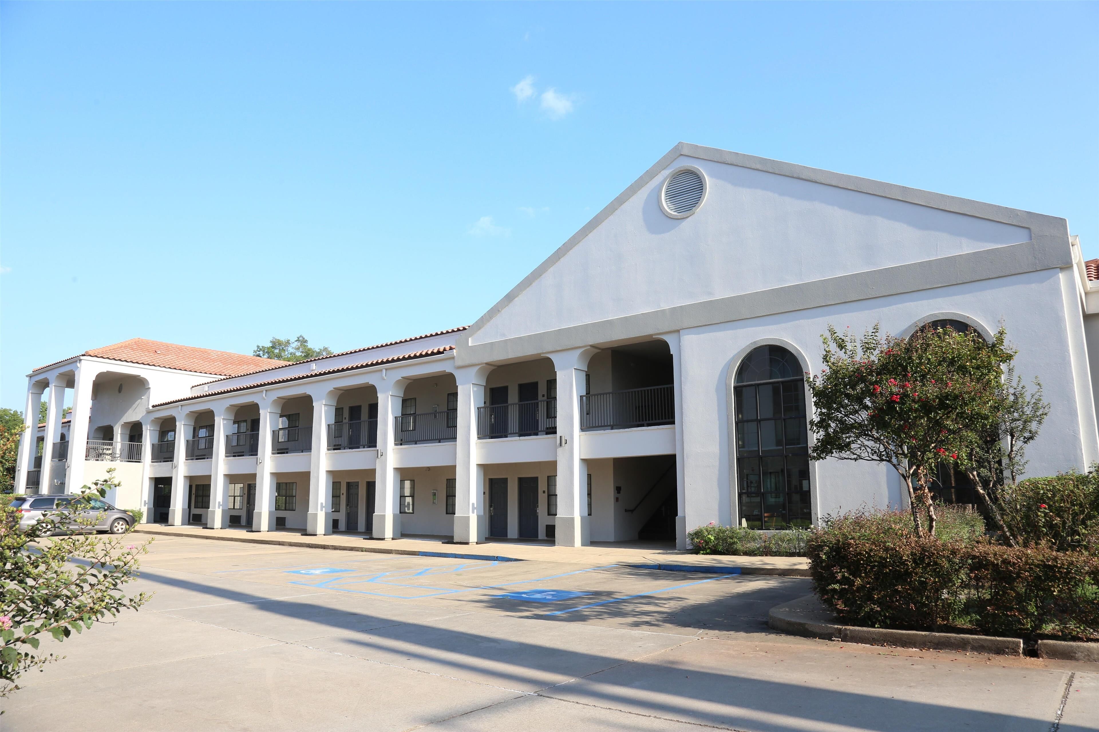 A white building with multiple balconies and large windows, likely a hotel or public building.