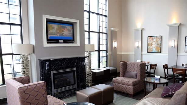 A spacious lobby with a fireplace, comfortable seating, a television, and large windows. - Americas Best Value Inn Monroe (Monroe)