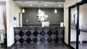 A reception area with a marble counter, pendant lighting, and a large mirror on the wall. - Americas Best Value Inn Monroe (Monroe)