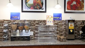 A self-serve breakfast station with labeled dispensers for grains & dairy and yogurt & pastries.