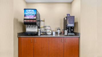 A coffee station with an Ocean Spray dispenser, a coffee maker, and a microwave.