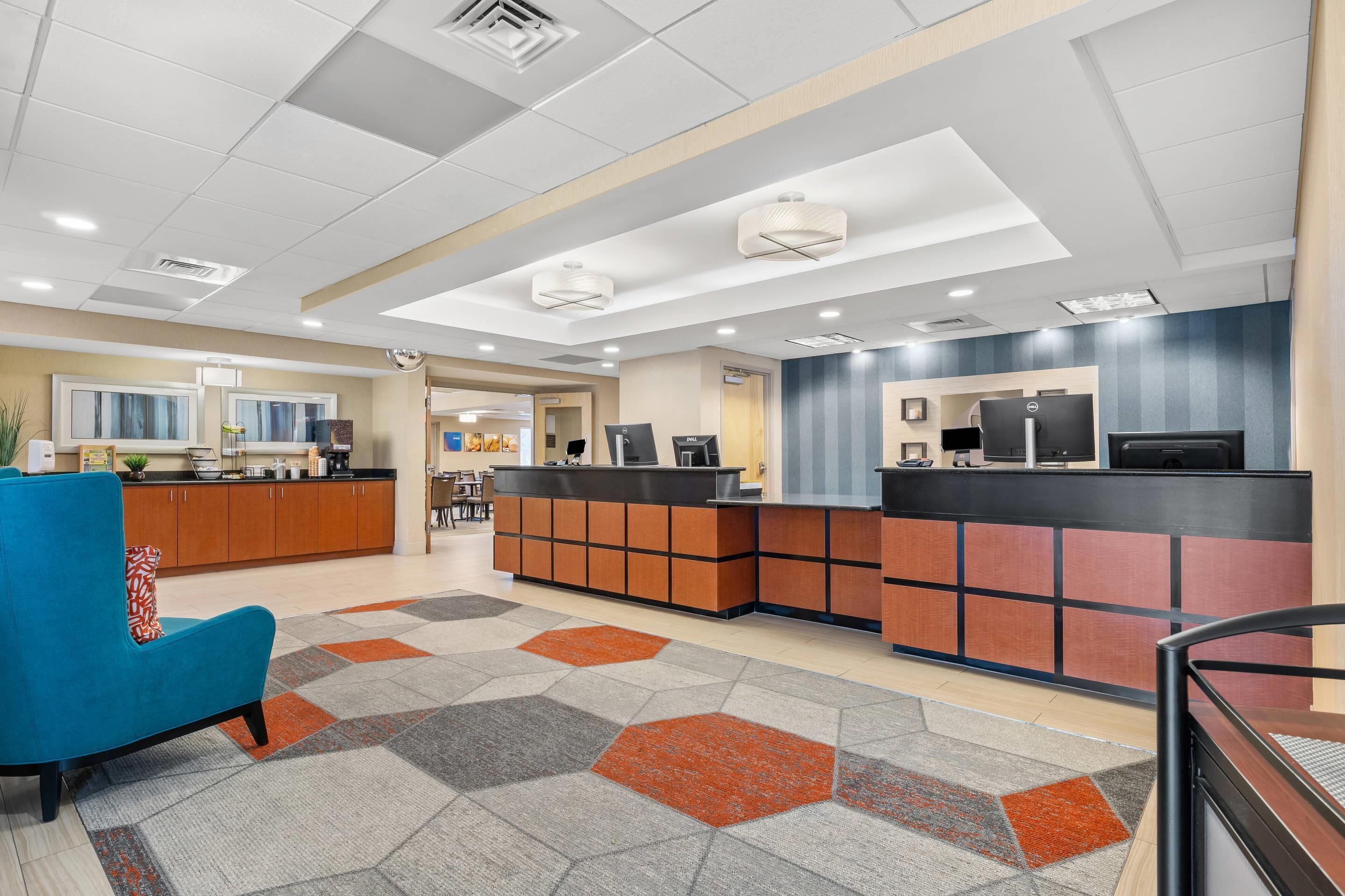 A reception area with a counter, seating, and a patterned carpet.
