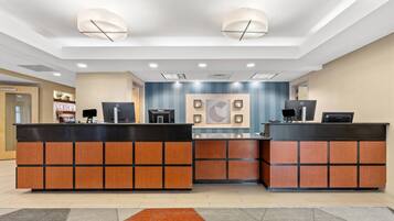 A reception desk with two computer stations, a wall-mounted phone, and a blue accent wall.