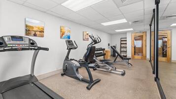 A gym with treadmills, elliptical machines, and weight benches.