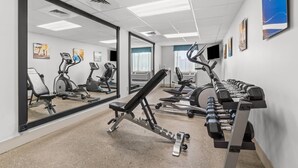 A gym with exercise equipment, mirrors, and motivational posters. - Comfort Inn Rehoboth Beach (Rehoboth Beach)
