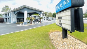 A motel with a sign reading "RELAX INN" and "WELCOME TO PERRY". - Relax Inn Perry (Perry)