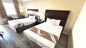 A hotel room with two beds, a desk, a chair, and a lamp. - Relax Inn Perry (Perry)