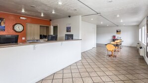 A reception area with a clock, a ViewSonic monitor, and a counter. There are tables and chairs in the background.