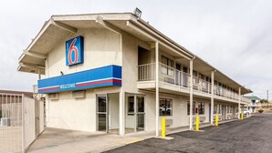 A motel with a '6' sign, a 'WELCOME' sign, and a two-story structure with balconies.