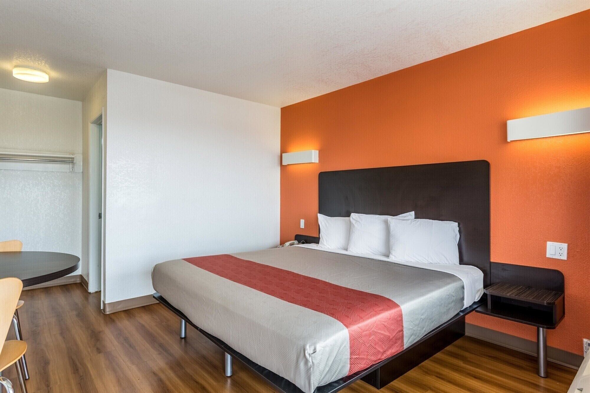 A hotel room with a bed, a desk, and a chair.