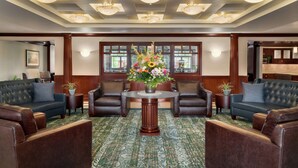 A lobby with a round table, two sofas, and a floral centerpiece. - Homewood Suites by Hilton Wilmington-Brandywine Valley (Wilmington)