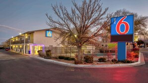 A motel with a prominent '6' sign, a well-lit entrance, and a fenced parking area. - Motel 6 Santa Fe (Santa Fe)