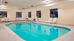 An indoor swimming pool with clear blue water, surrounded by white lounge chairs and a tiled floor. - Days Inn by Wyndham Boonville (Boonville)