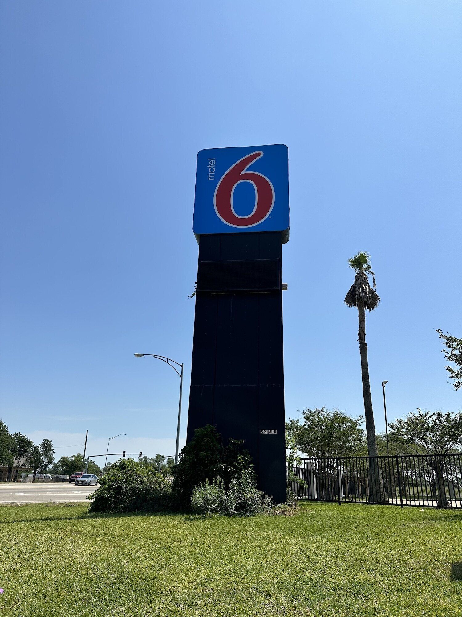 Un cartel alto y de color oscuro de motel con el número '6' bien visible.