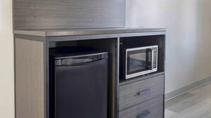 A compact kitchen with a built-in microwave and a refrigerator. - Motel 6 Lake Charles, LA (Lake Charles)
