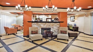 A lobby with a fireplace, seating area, and a reception desk. - Holiday Inn Express Peachtree Corners - Norcross by IHG (Peachtree Corners)