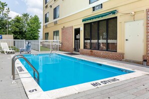 A rectangular pool with a metal ladder, surrounded by a white fence. - Comfort Suites Dover University Area (Dover)