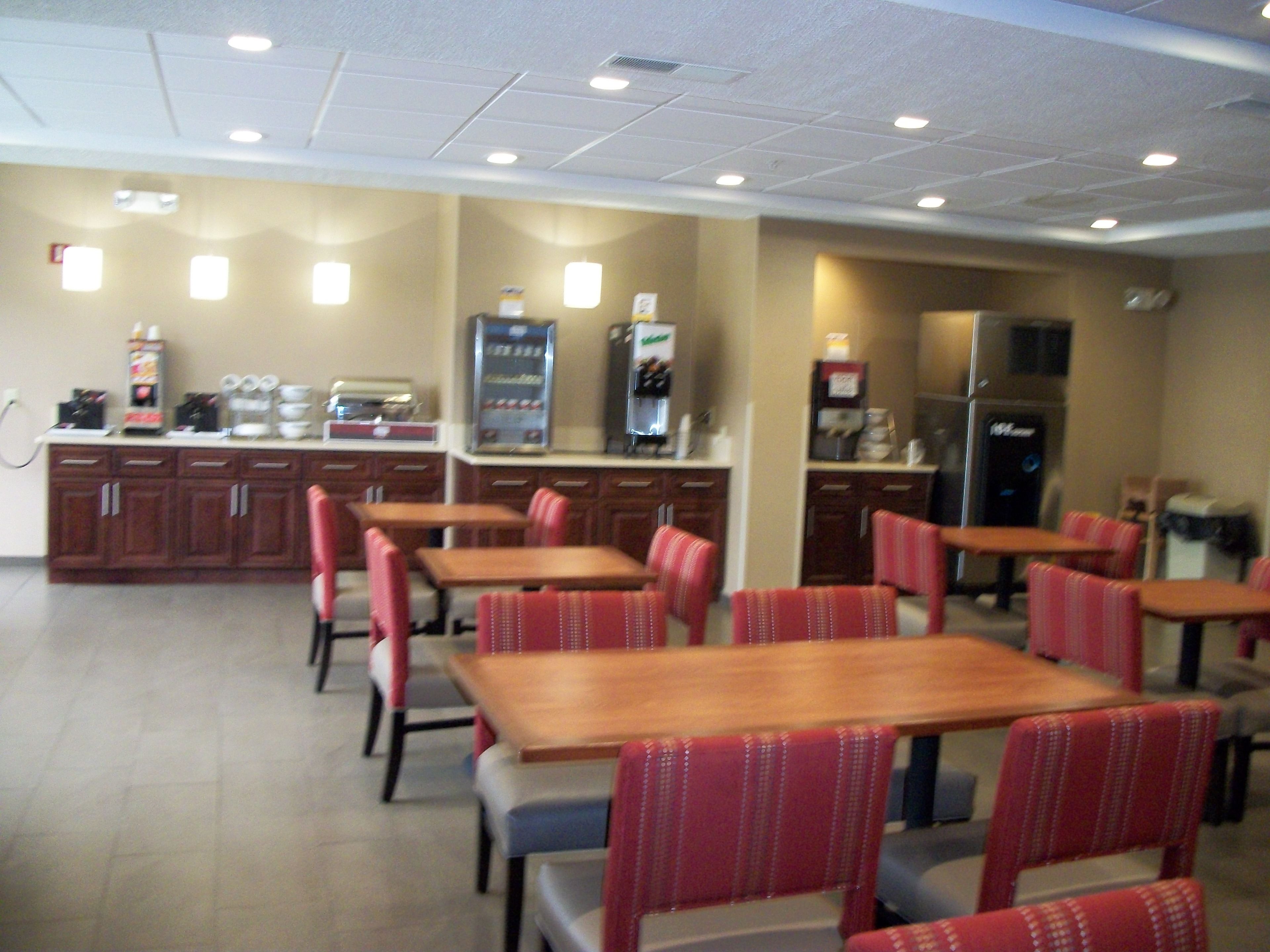 A dining area with tables and chairs, a kitchen area with appliances, and a vending machine.