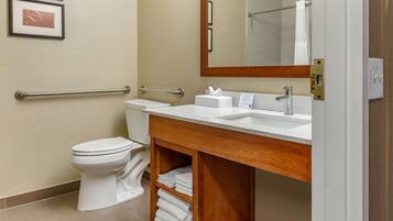 A modern bathroom with a white toilet, a sink with a mirror, and a towel rack.