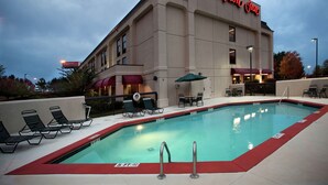 Ein Hotel mit Pool, Liegestühlen und Außenbereich.