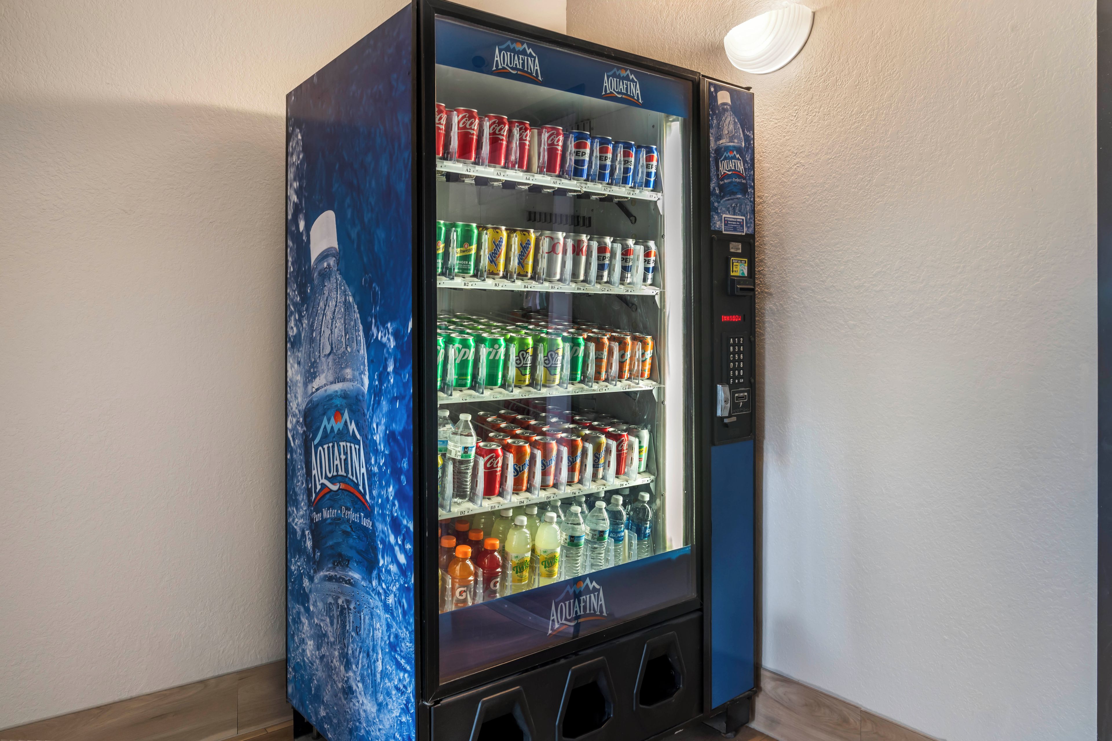 A vending machine with multiple beverage options including Coca-Cola, Pepsi, and Aquafina water.