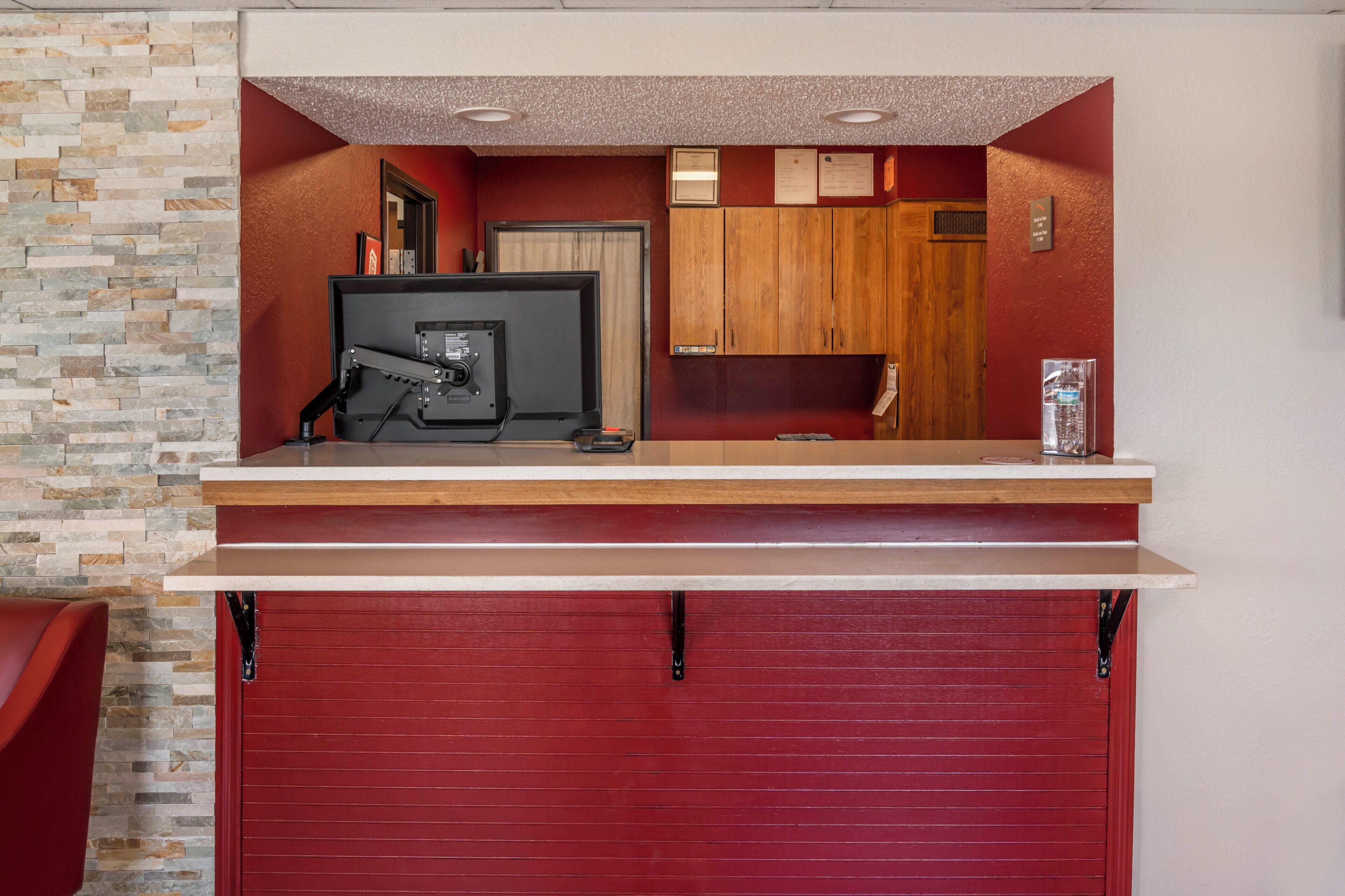 A garage with a red door, a workbench, and a water dispenser.