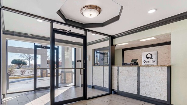 A hotel reception area with a glass door entrance, a reception desk, and a sign indicating "Quality by Choice Hotels". - Quality Inn & Suites Morrow Atlanta South (Morrow)