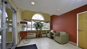 A room with a wheelchair, a small table, a chair, and a door.