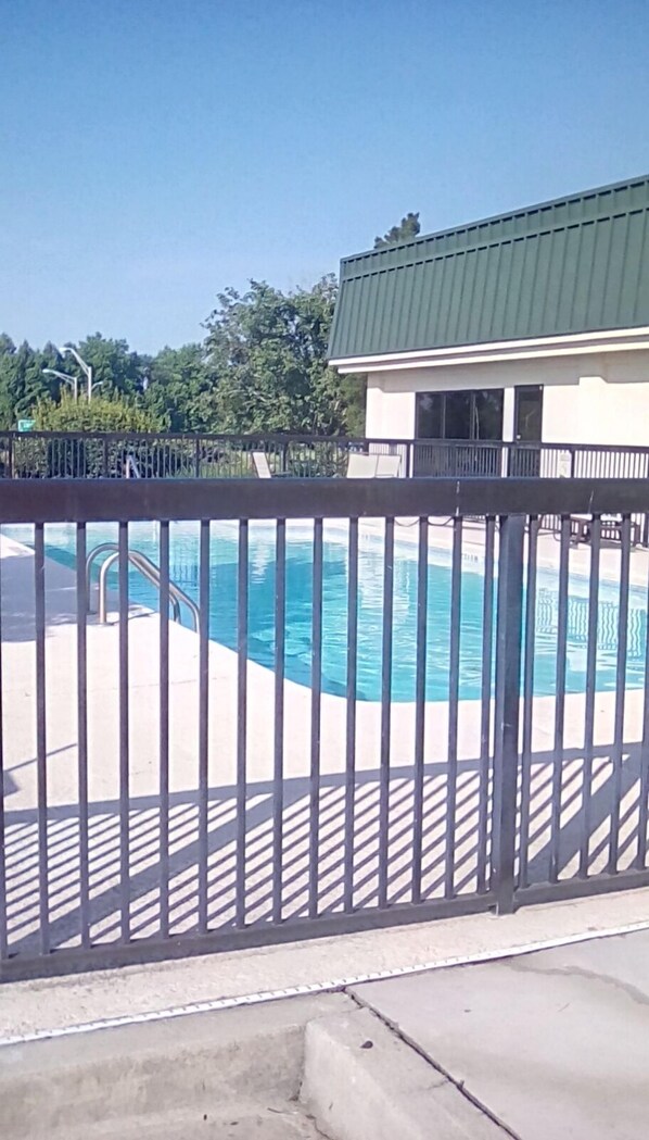 Una piscina al aire libre de temporada, sillones reclinables de piscina